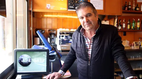 El propietari del cafè Estació, Josep Maria Salvadó, al costat de la màquina de loteria amb la qual han venut un tercer premi del sorteig de Reis. Autor: Anna Berga