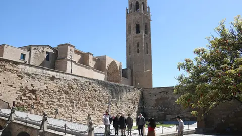 Un grup de persones es fa una fotografia amb la Seu Vella al fons. Foto: ACN