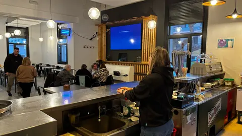 Treballadora dle bar i al fons unes dones fent el cafè. Foto_ Oriol Almacellas