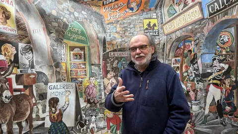 L'historiador Cisco Farràs davant el mural que recrea les futures galeries Monsó que impulsa a Salàs de Pallars. Foto: ACN