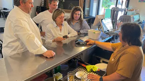Persones retiren diners en efectiu a través del nou servei dels Alamús que permet treure diners mitjançant el datàfon del bar social