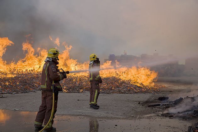 El bombers mullen les pares de la nau per evitar danys a l'estructura i que es propagui a l'interior.