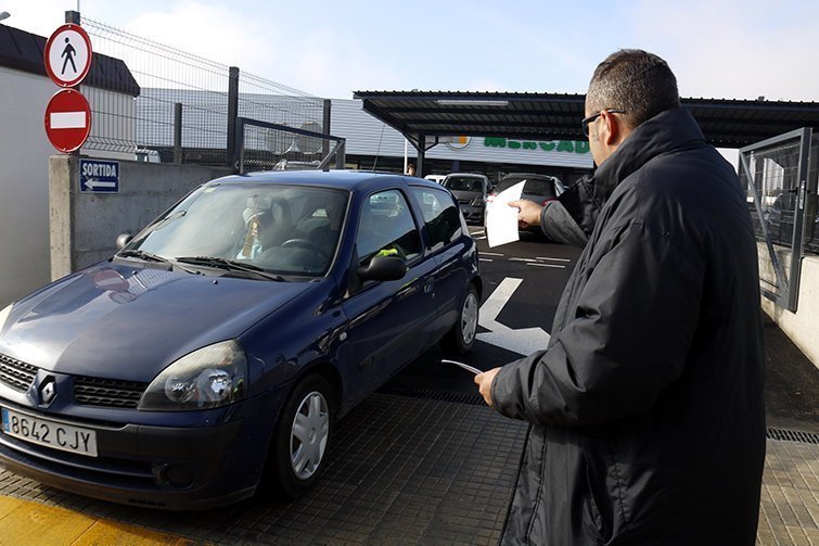 Un parell de pagesos entregant el manifest de la protesta pels preus baixos de la fruita als clients que surten del nou Mercadona de Mollerussa, el 28 de novembre de 2016. (Horitzontal)