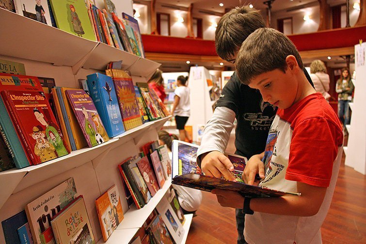 Dos nens llegeixen un llibre al Teatre l'Amistat de Mollerussa en una imatge d'arxiu (horitzontal).