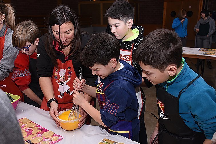 Les monitores ensenyen com es prepara la massa de les galetes