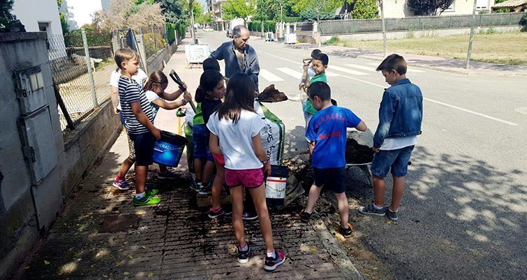 Els escolars planten arbres en el carrer  Clos d'Agramunt