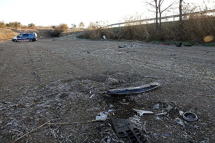 En primer pla, restes del vehicle accidentat mortalment a l'N-II a Castellnou de Seana, i al fons una furgoneta dels Mossos d'Esquadra al camp on ha caigut, el 4 de desembre de 2017. (Horitzontal)