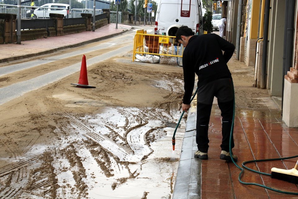Un veí traient aigua en una de les zones de balaguer afectades per l'aiguat