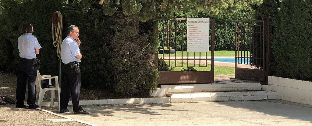 La porta del recinte de les piscines del Club Tennis Borges, custodiada per dos agents dels Mossos d’Esquadra