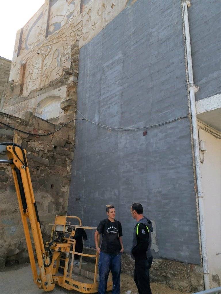 L'artista Ana Pulido davant la paret on realitza el mural del Pessebre Vivent de Linyola