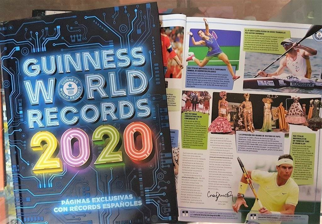 El llibre del Guinness World Records 2020, amb la mostra dels vestits de paper entre les sevs pàgines. El llibre del Guinness World Records 2020, amb la mostra dels vestits de paper entre les sevs pàgines.