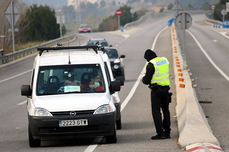 Un agent aturant un cotxe que vol sortir d'Igualada després de dur material mèdic a l'hospital