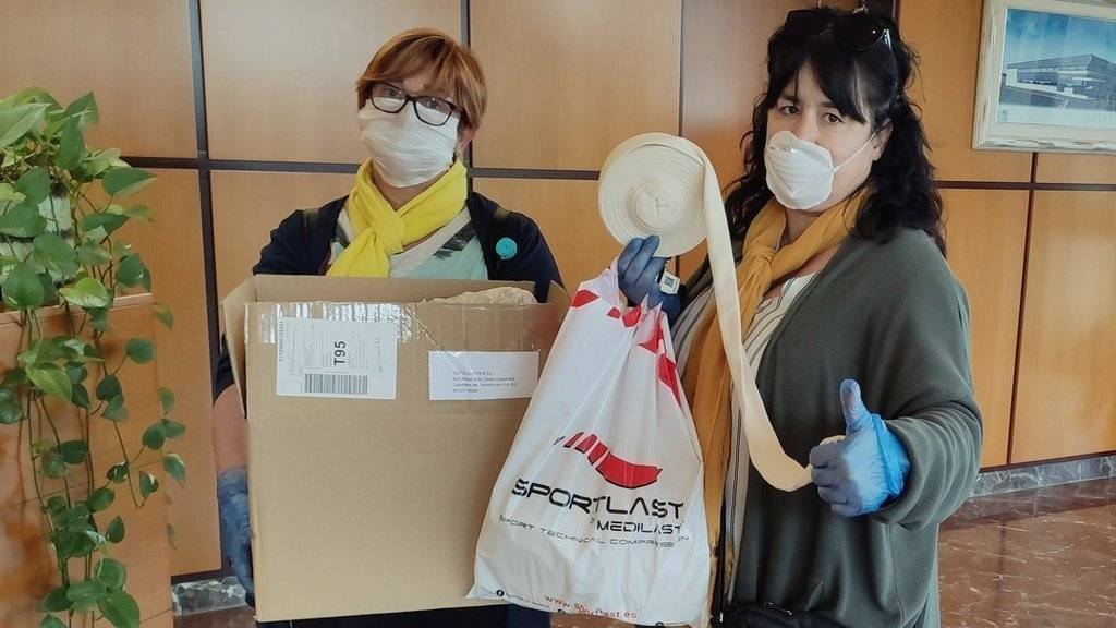 Representants de la firma Medilast lliurant material NEOTUB per a l'elaboració domèstica de mascaretes, el 23 de març del 2020. (Vertical)