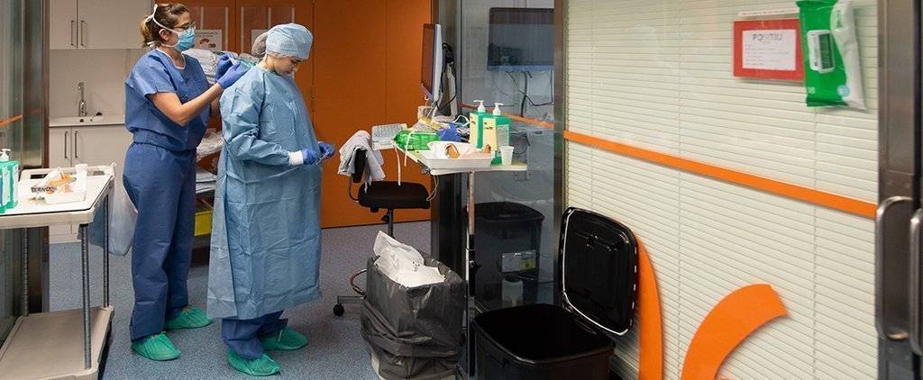 Una professional sanitària es protegeix abans d'entrar en una habitació