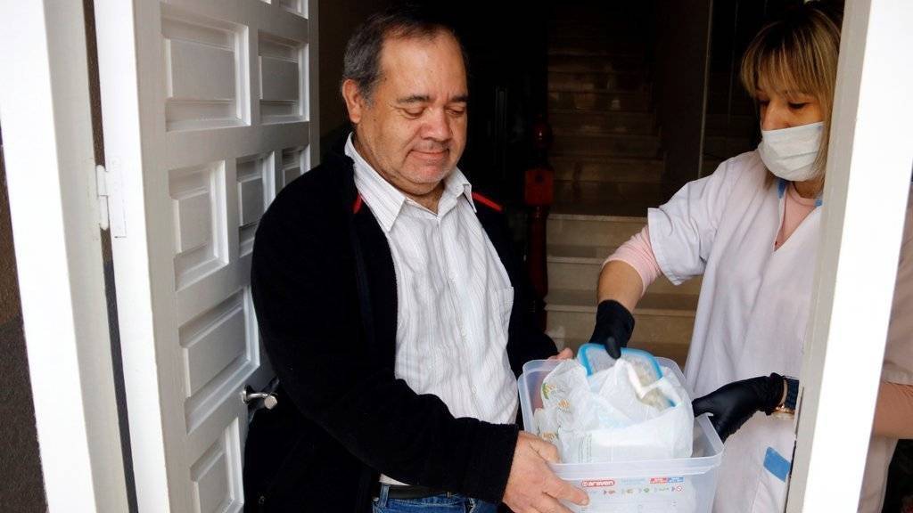 Pla mitjà on es pot veure un moment del repartiment de menjar preparat a domicili per la crisi del coronavirus, a Mollerussa, el 31 de març de 2020. (Horitzontal)