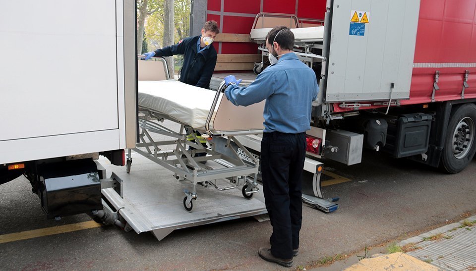 Els Bombers de la Generalitat descarregant llits articulats al pavelló Onze de Setembre de Lleida