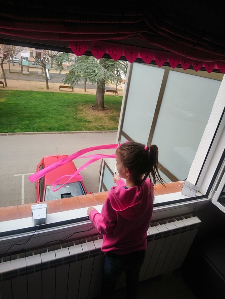 una nena mentre balla la cançó a la finestra