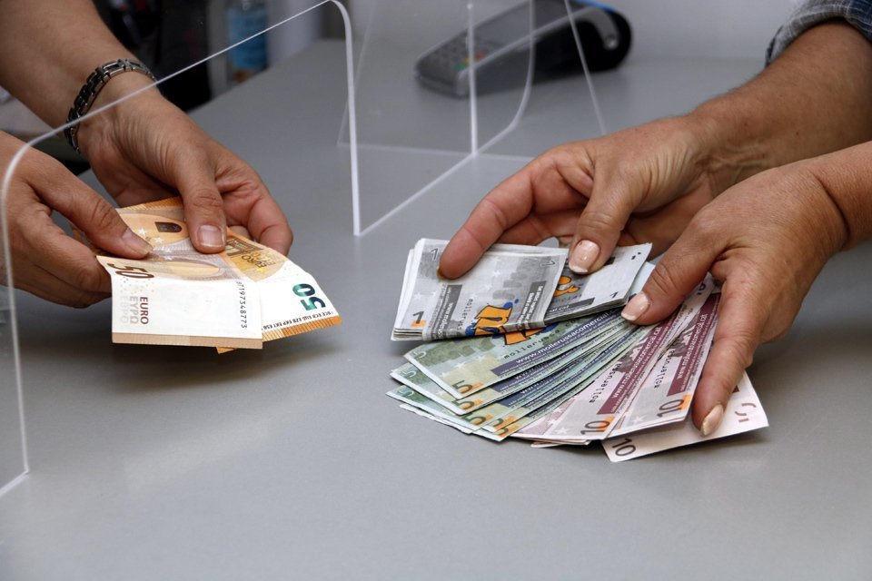 Pla curt on es poden veure molleuros i euros en una operació de canvi en el marc d'una campanya de Mollerussa Comercial per incentivar les compres locals arran de la crisi de la covid-19, el 25 de maig de 2020. (Horitzontal)