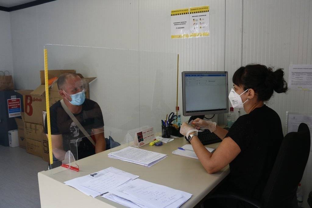 Pla mitjà on es pot veure el Yassin, un temporer arribat a Lleida per treballar a la fruita, mentre rep atenció a l'oficina única dels pavellons de Fira de Lleida, el 7 de juliol de 2020. (Horitzontal)