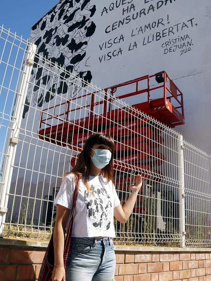 L'artista Cristina Dejuan mostrant el mural "censurat" que havia començat a fer Torrefarrera