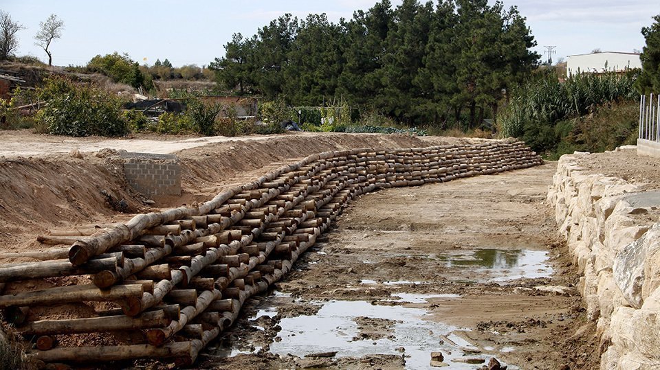 Un mur de troncs construït a la llera del riu Gorgs, al seu pas per l'Albi