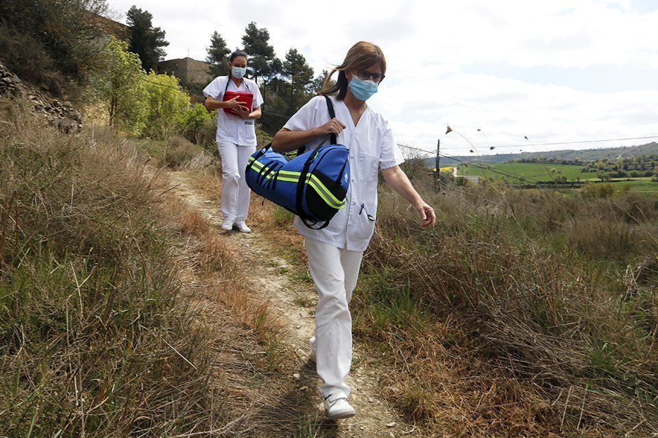Pla mitjà on es poden veure dues infermeres caminant per un corriol durant el trasllat d'una vacuna contra la covid-19, a Ivorra, a la Segarra, el 8 d'abril de 2021. (Horitzontal)