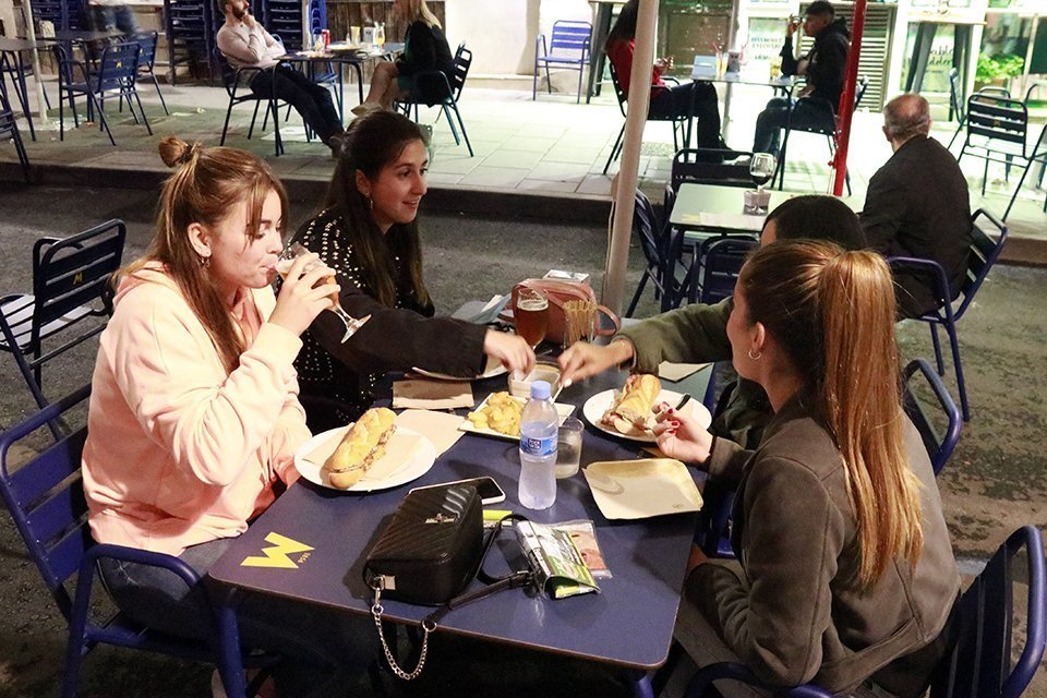 Pla obert d'un grup de quatre noies sopant a la terrassa d'un restaurant de Lleida, el 9 de maig de 2021. (Horitzontal)