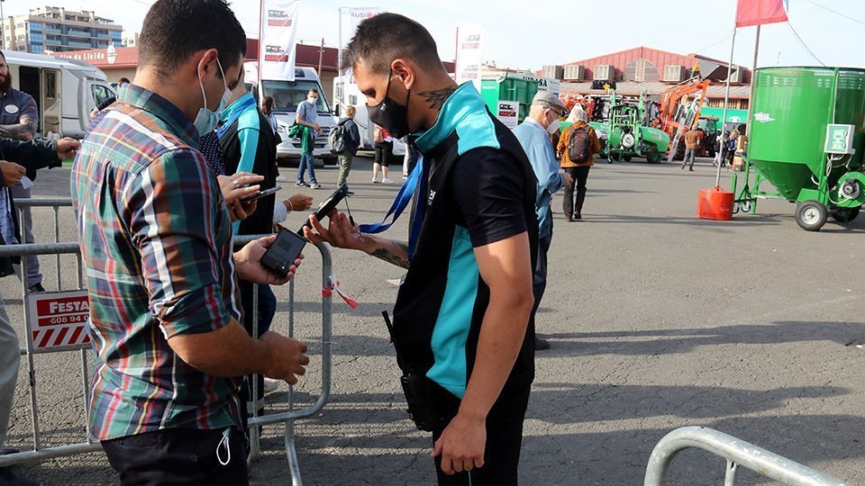 Visitant mostrant l'entrada per accedir a la Fira de Sant Miquel
