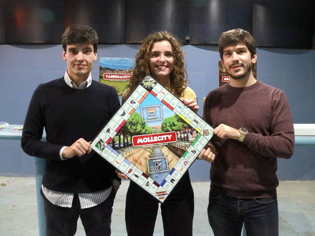 Anna BergaPla mitjà dels dos ideòlegs de 'YOURCITY', Jordi Noguera i Oriol Farràs, amb la també impulsora del joc 'Mollecity', Marta Timoneda, mostrant el taulell del joc, el 29 d'octubre de 2021. (Horitzontal)